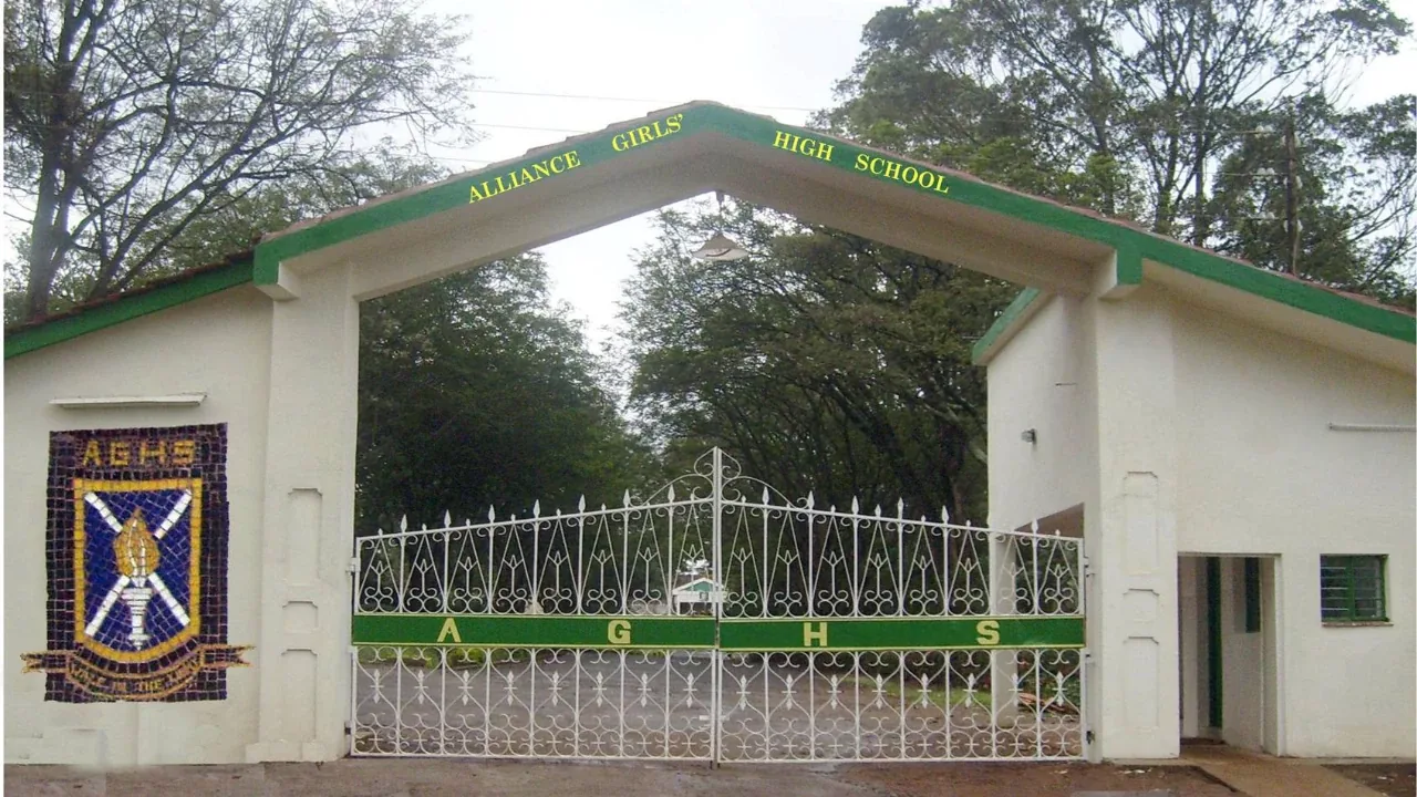 The main gate, bearing the school crest and motto